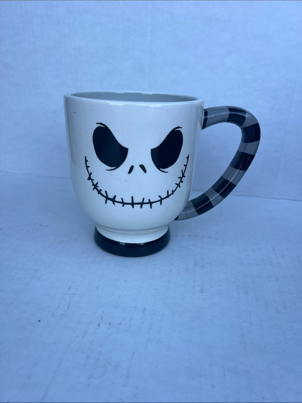 White Ceramic Mug with Black Skull Face and Striped Handle